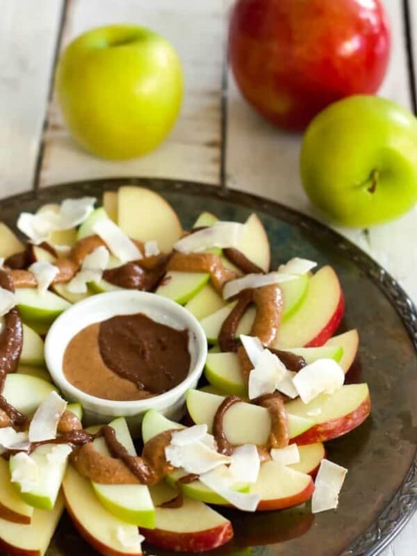a plate of healthy apple nachos with apples on a white board