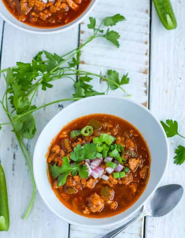 Two bowls of whole30 instant pot turkey chili with toppings and cilantro