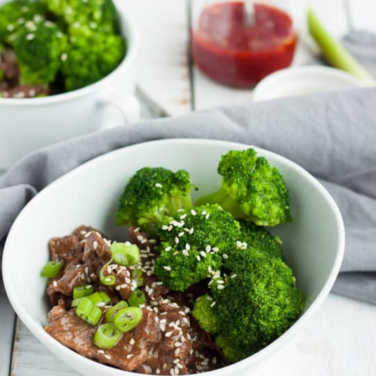two bowls of instant pot paleo beef and broccoli with hot sauce