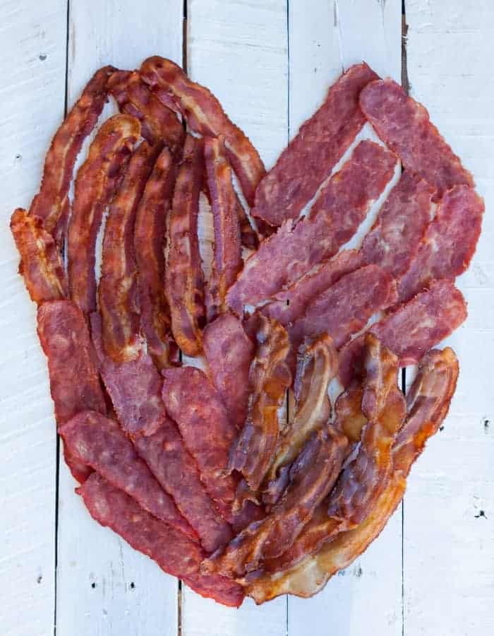 A heart made out of bacon on a white board