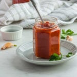 a jar of whole30 bbq sauce with garlic and parsley