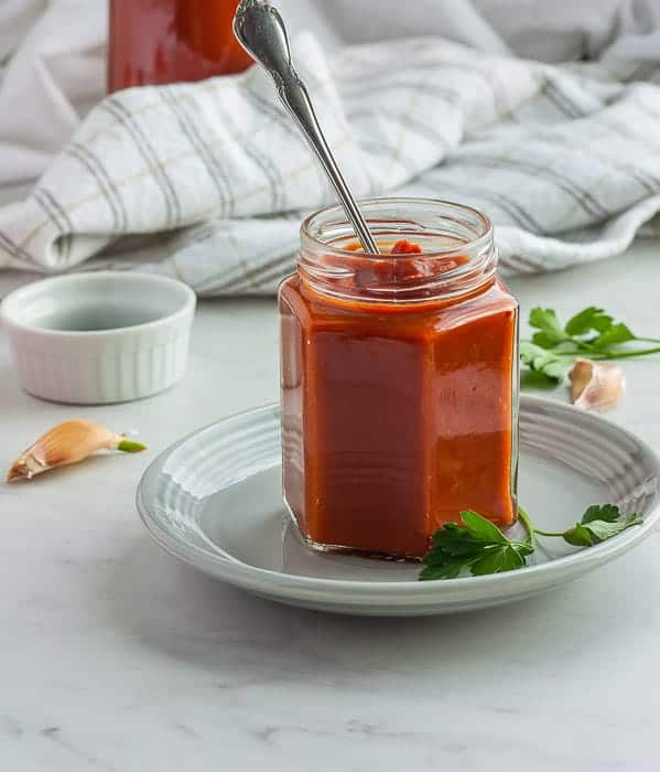 a jar of whole30 bbq sauce with garlic and parsley
