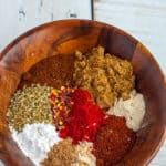 Various seasonings for making whole30 taco seasoning in a wooden bowl