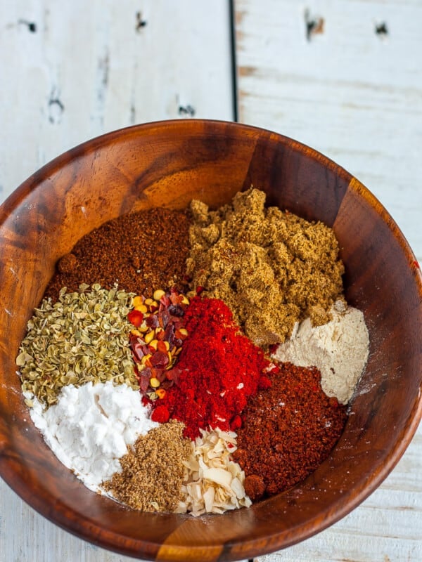 Various seasonings for making whole30 taco seasoning in a wooden bowl