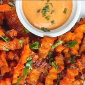 a plate of crinkle cut butternut squash fries with a dipping sauce
