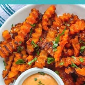 a plate of crinkle cut butternut squash fries with a dipping sauce