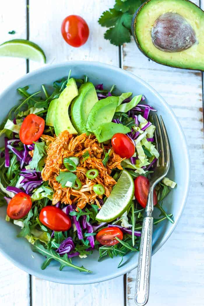 a grey bowl with salad, avocado, tomatoes, and pressure cooker chicken taco meat 