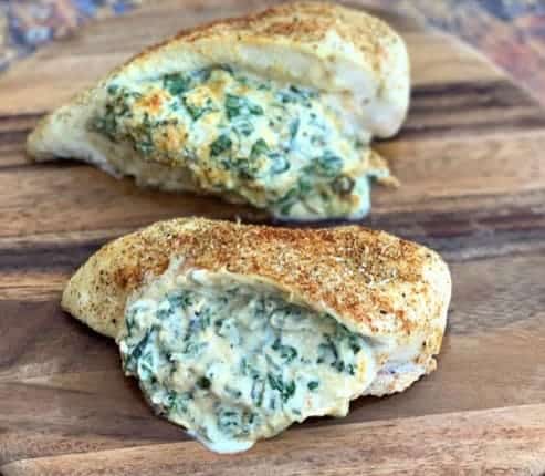 spinach stuffed chicken breast on a wooden cutting board