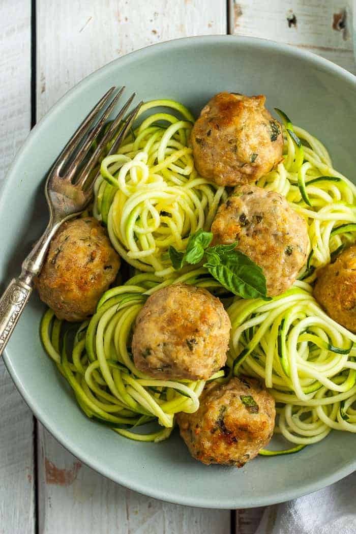 an overhead shot of a bowl of baked glutenfree turkey meatballs and zoodles