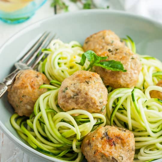 a bowl of zoodles with greek turkey meatballs and basil