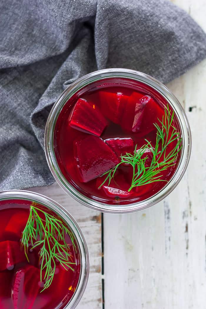 a glass jar of quick-pickled beets topped with fresh dill