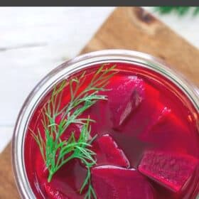 a glass jar of refrigerator pickled beets topped with fresh dill