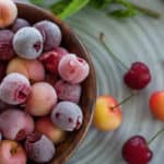 a wooden bowl with frozen cherries