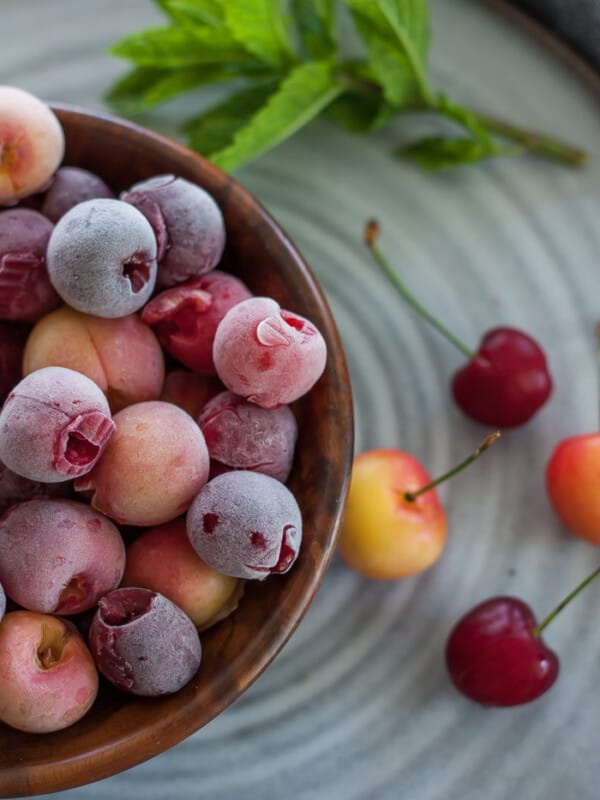 a wooden bowl with frozen cherries