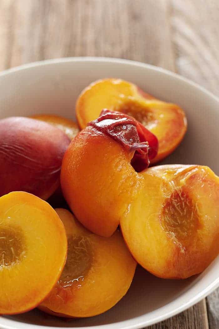 a bowl of skinless peaches