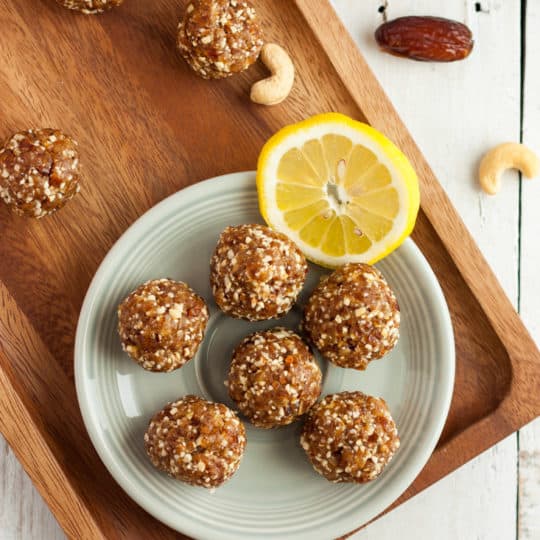 a plate of lemon bliss balls with cashews and almonds