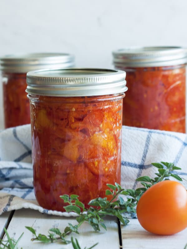 three jars of canned stewed tomatoes with herbs