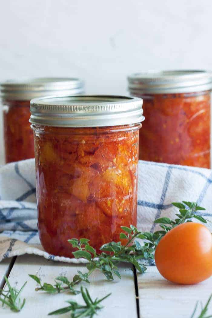 three jars of canned stewed tomatoes with herbs