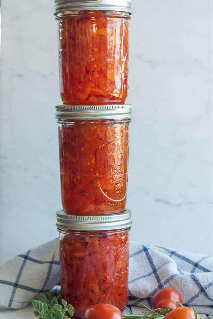 Three jars of stewed tomatoes stacked on each other