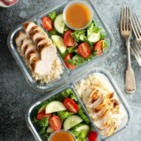 two glass containers with meal prepped food and forks