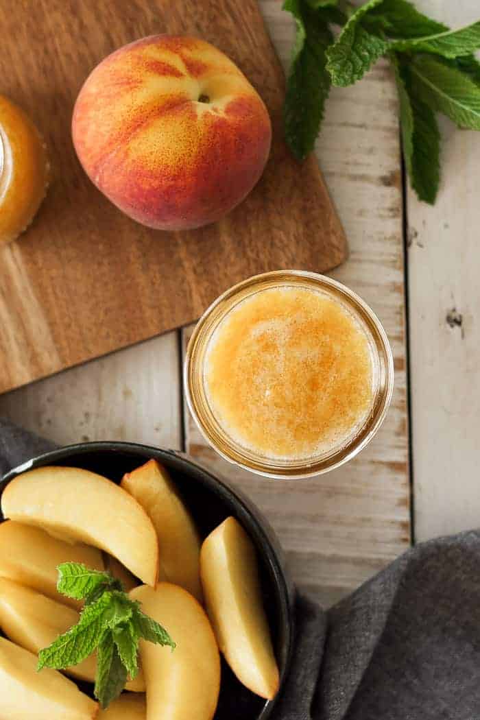 peach freezer jam with sliced peaches and mint