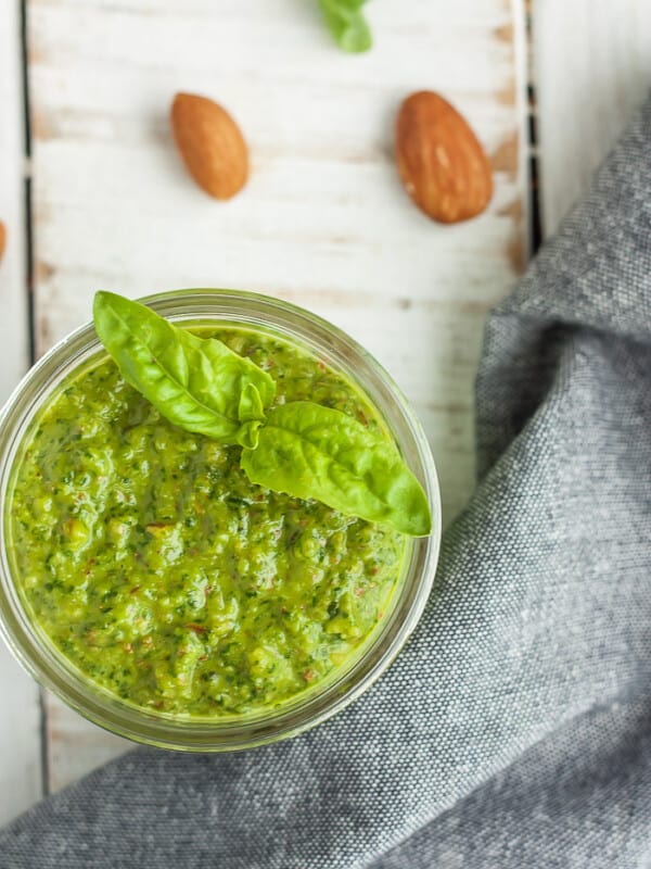 a small jar of vegan pesto with almonds and a grey cloth