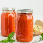 canning jars of tomato soup with herbs and garlic bread