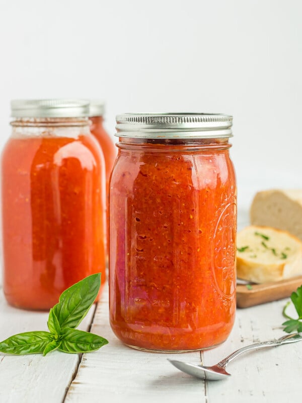 canning jars of tomato soup with herbs and garlic bread