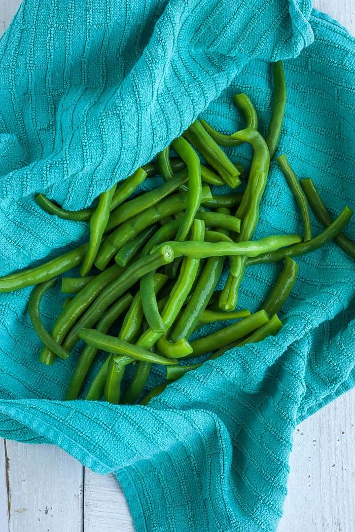 blanched green beans in a teal towel