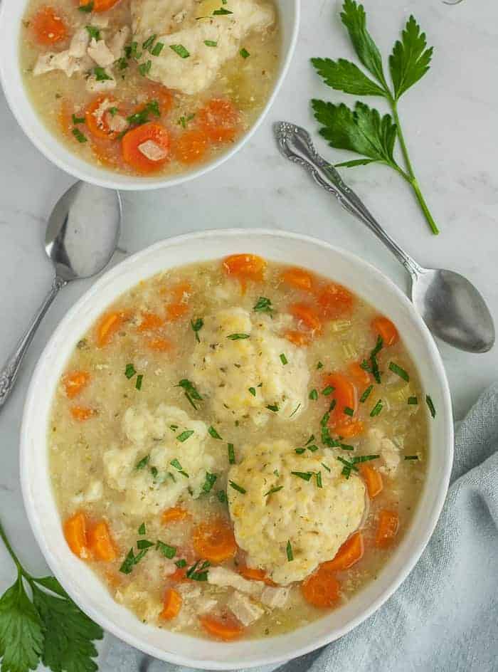 two bowls of healthy chicken and dumplings with herbs