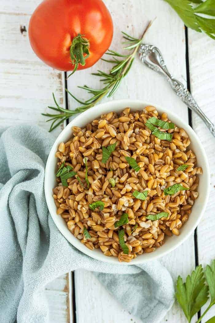 a bowl of instant pot farro with herbs and tomatoes