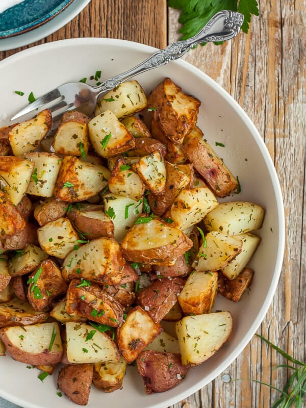 A bowl of crispy fried potatoes topped with parsley