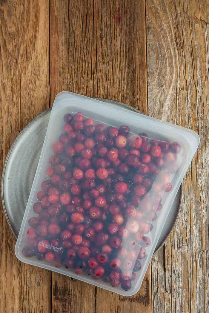 a bag of cranberries in a reusable freezer bag on a grey plate