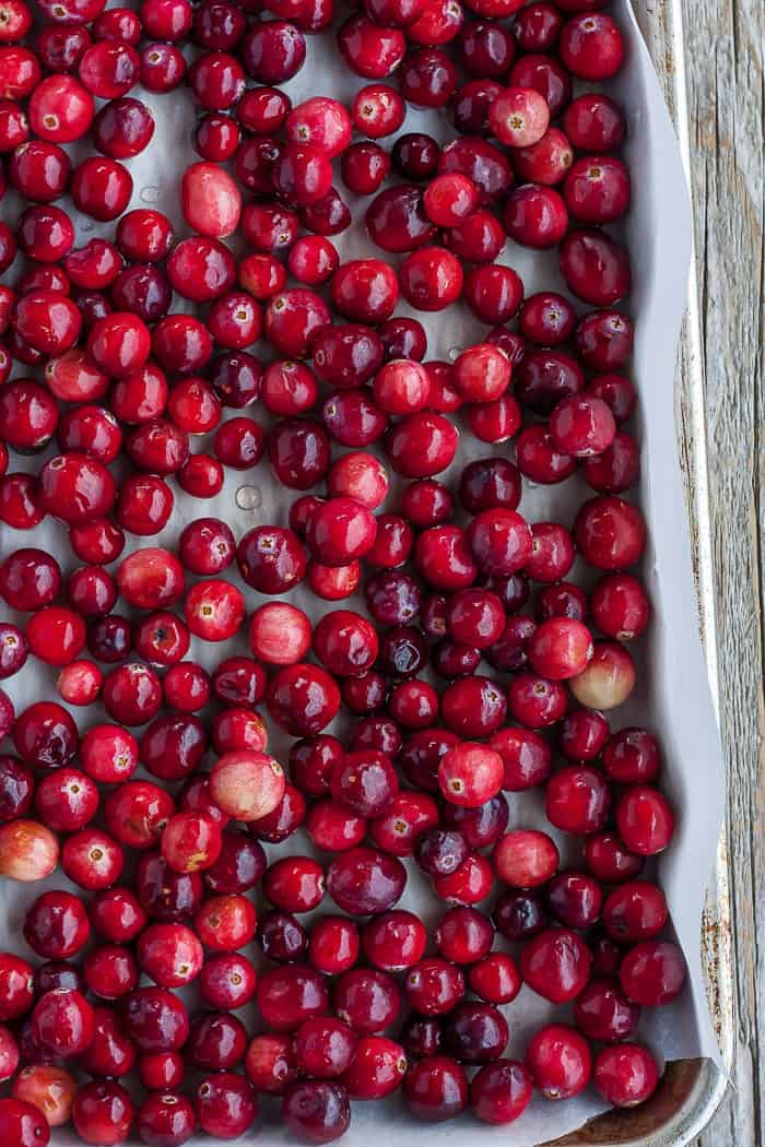 fresh cranberries on a rimmed baking sheet lined with parchment.