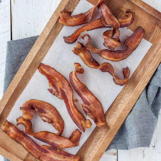 a wooden tray lined with parchment and bacon