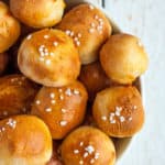 a dish of pretzel bites topped with salt on a white board