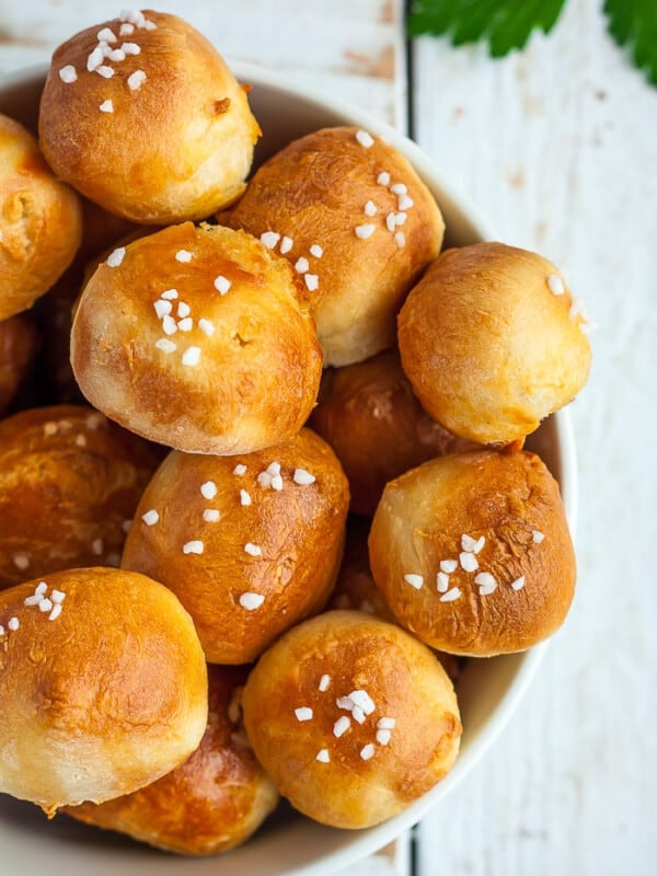 a dish of pretzel bites topped with salt on a white board