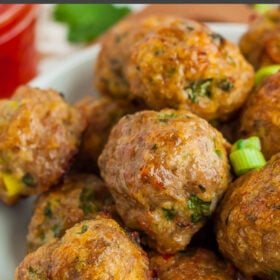 a plate of sweet chili meatballs topped with sliced green onions and a small dish of sweet chili sauce.