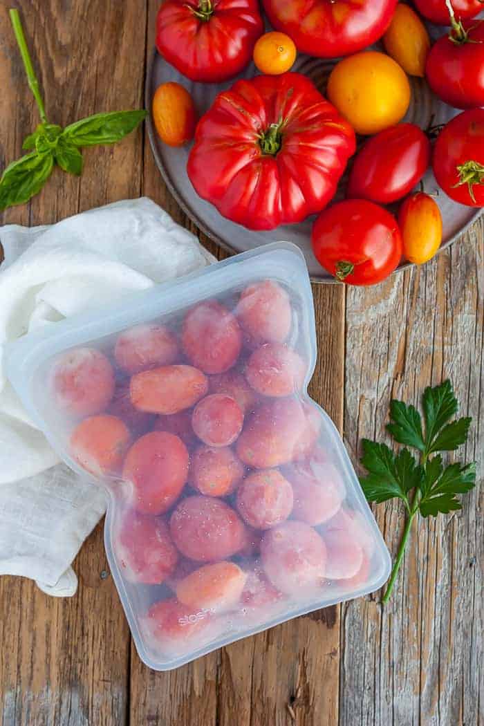 frozen tomatoes in a freezer bag on a wooden board