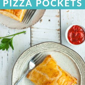 2 puff pastry pizza pockets sitting on plates with forks and dish of red sauce