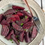 Air fryer roasted beets on a tan plate with a fork