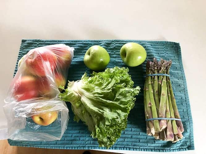 lettuce, apples, and asparagus on a blue towel