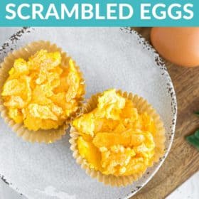 Frozen scrambled eggs on a grey plate on a cutting board with two whole eggs