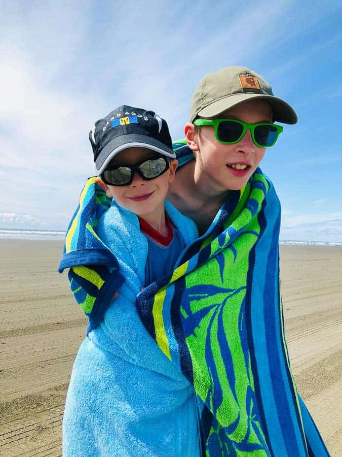 2 boys on a beach wrapped in a beach towel