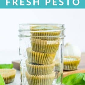 frozen cubes of pesto in a canning jar with basil on a white board