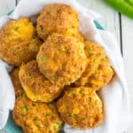 a plate of biscuits on a blue plate with chopped green chiles