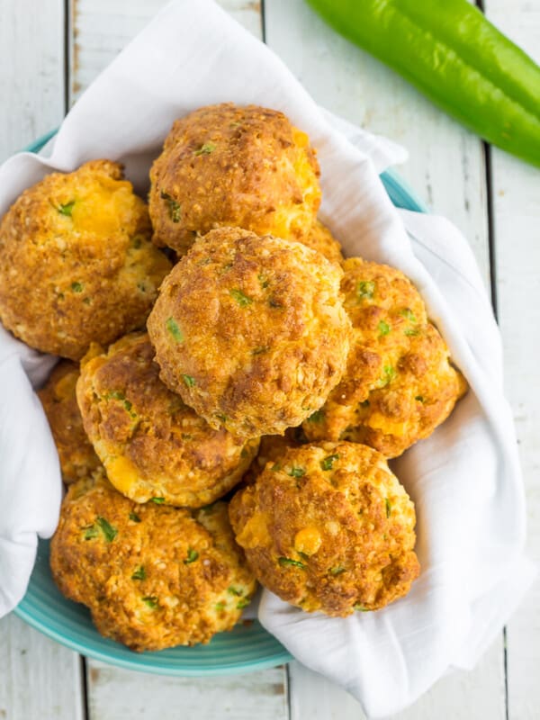 a plate of biscuits on a blue plate with chopped green chiles