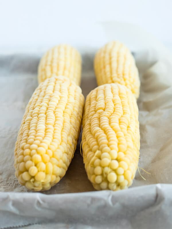 4 frozen ears of corn on a baking sheet