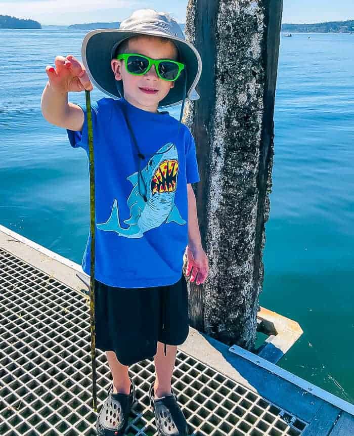 a boy holding a piece of kelp