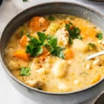 a grey bowl of Instant Pot chicken gnocchi soup with a spoon